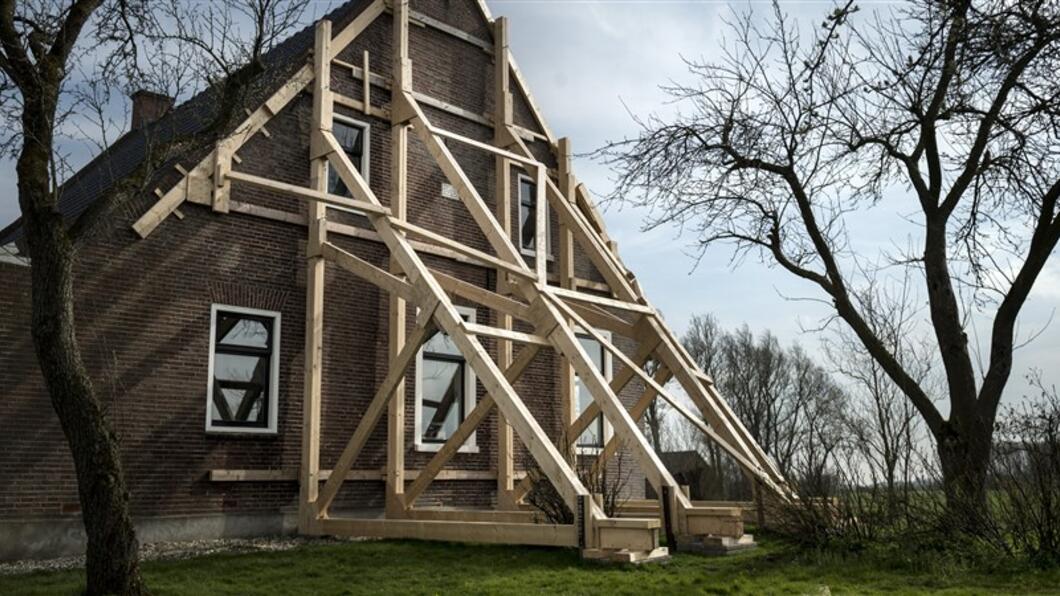 Huis in Groningen wordt ondersteund na aardbevingschade.