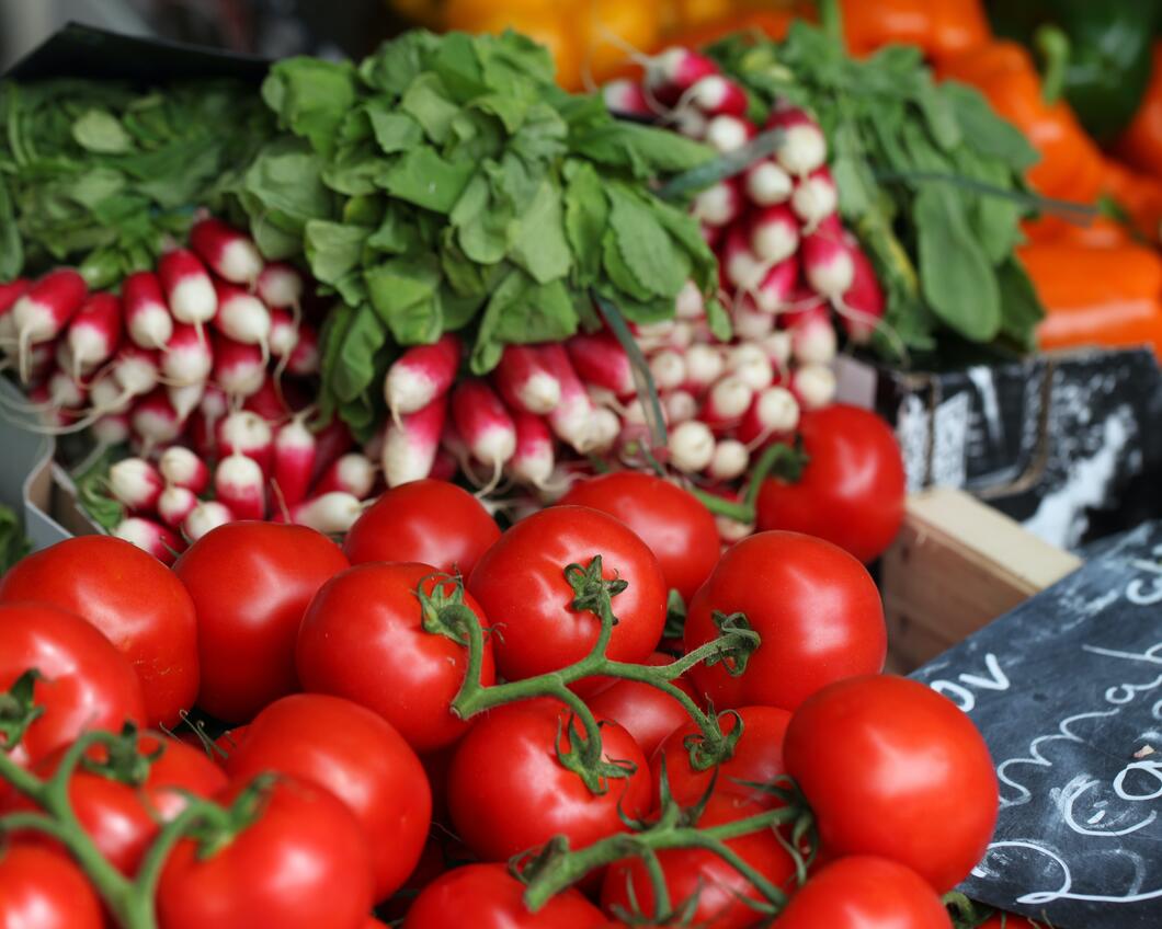 Tomaten en radijsjes uitgestald op een marktkraam.