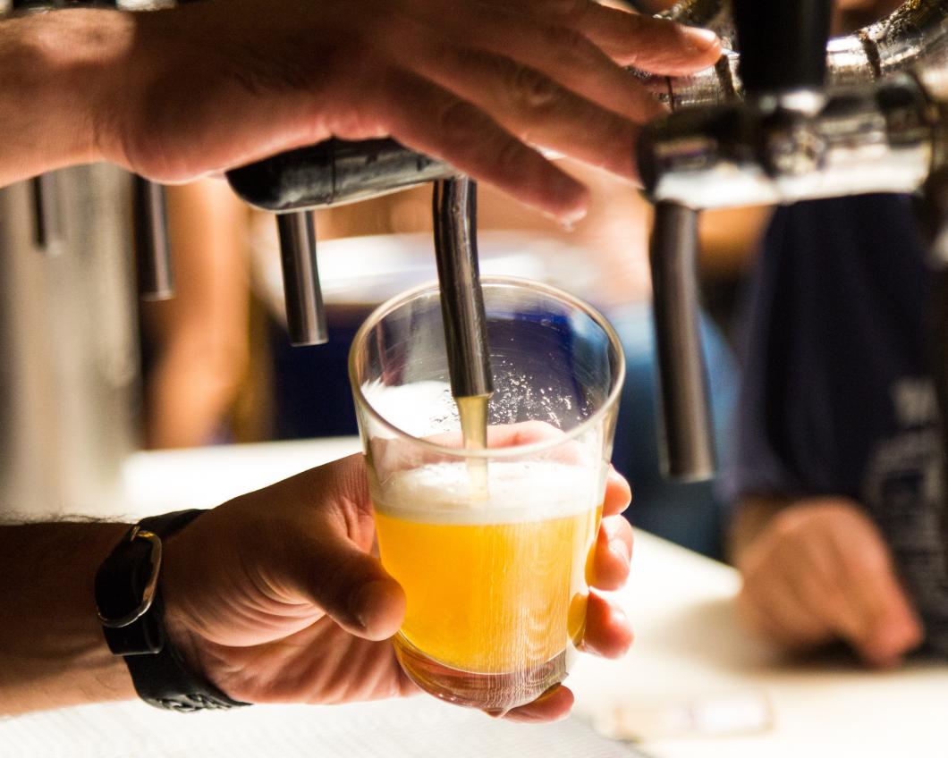Een barman tapt een biertje